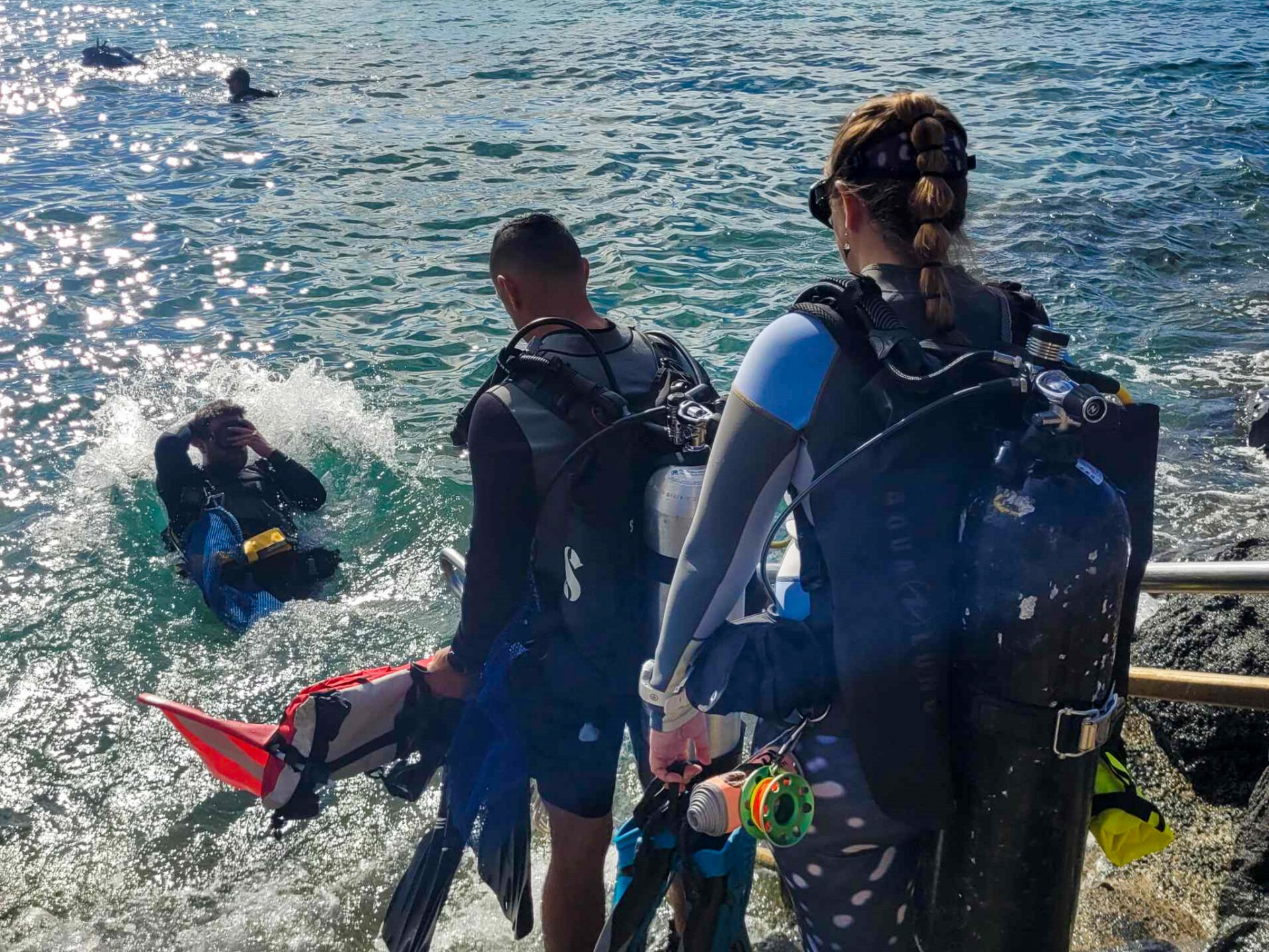 Nudi Wear volunteer divers entering the water