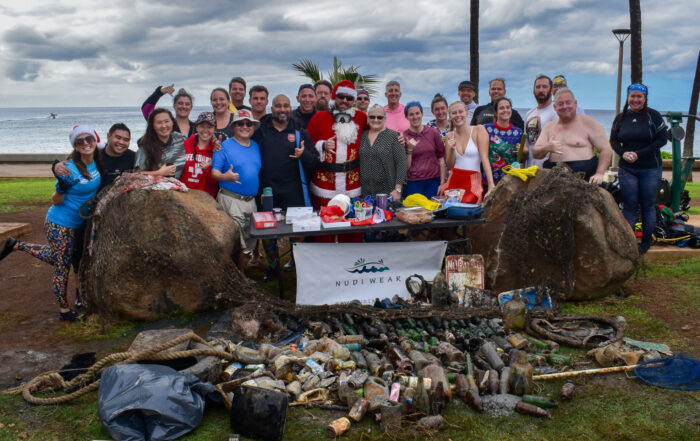 Nudi Wear & Trident volunteer divers pose with Santa and all the trash spread out on the ground that was removed during the cleanup dive