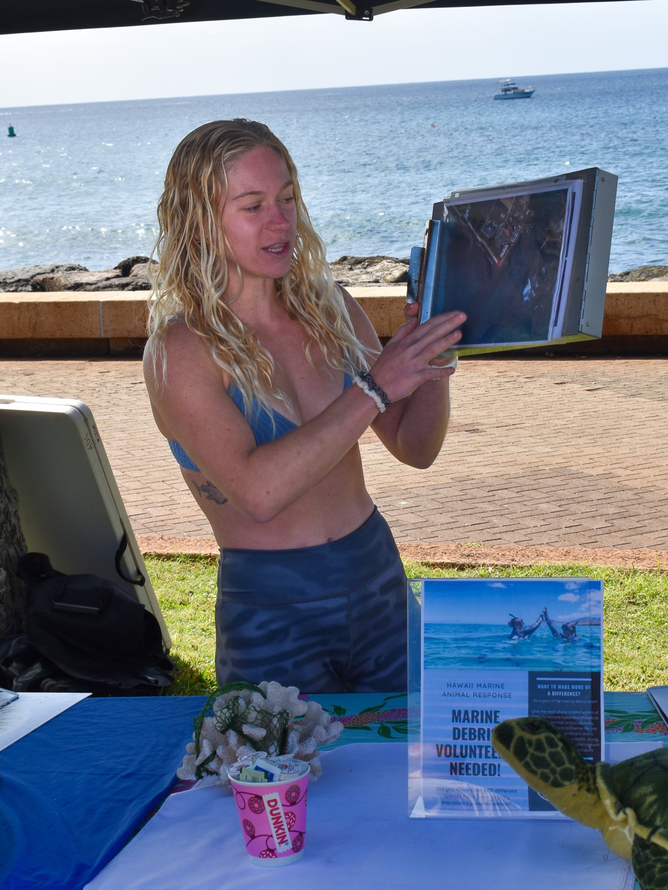 Jace Reinken, HMAR's Marine Debris Program led holding a clipboard with an image of the dive site at Point Panic while providing a briefing