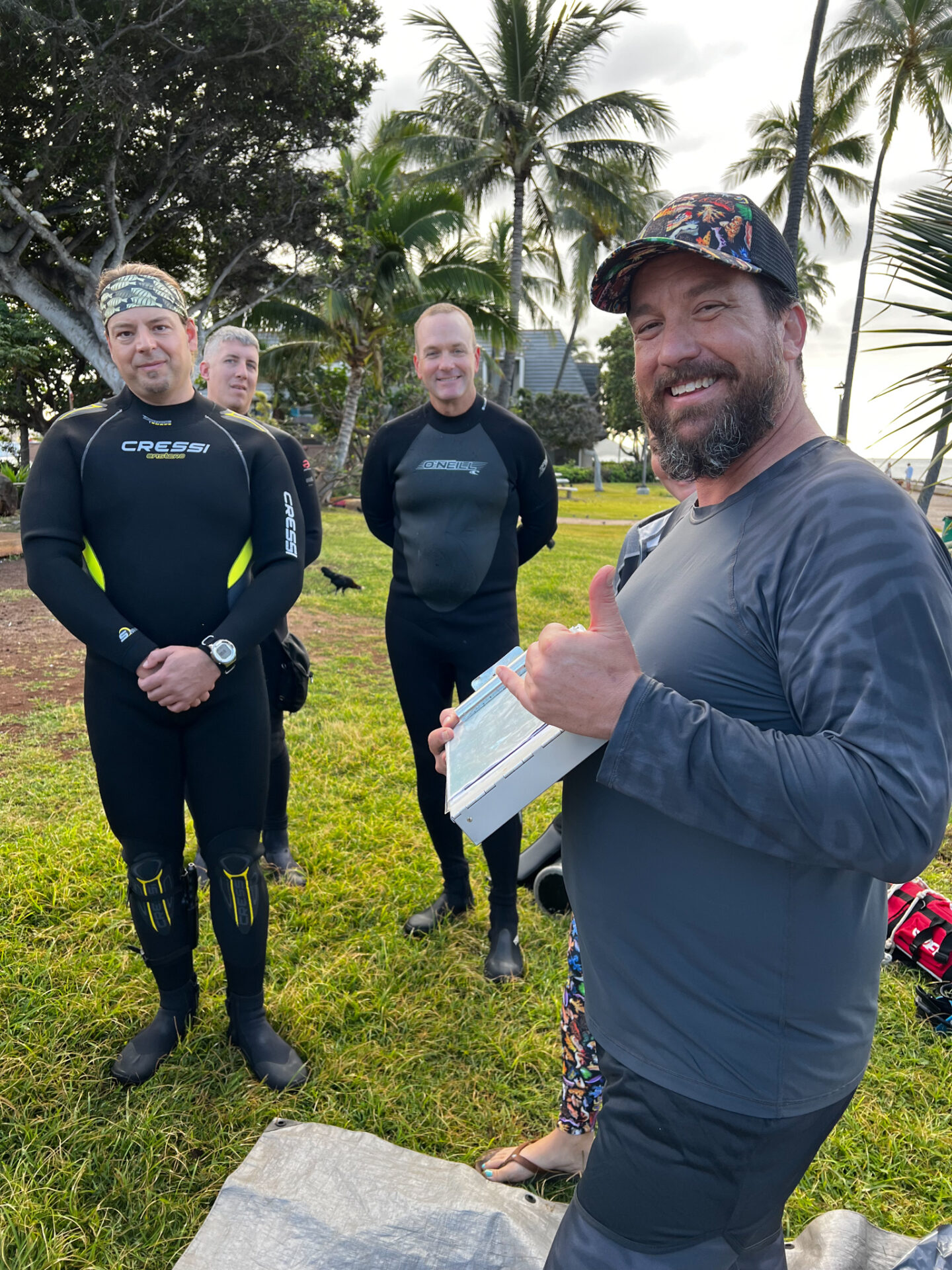 Nudi Wear co-owner, Ryan Scalf, holding an Point Panic dive site map while providing a briefing to divers