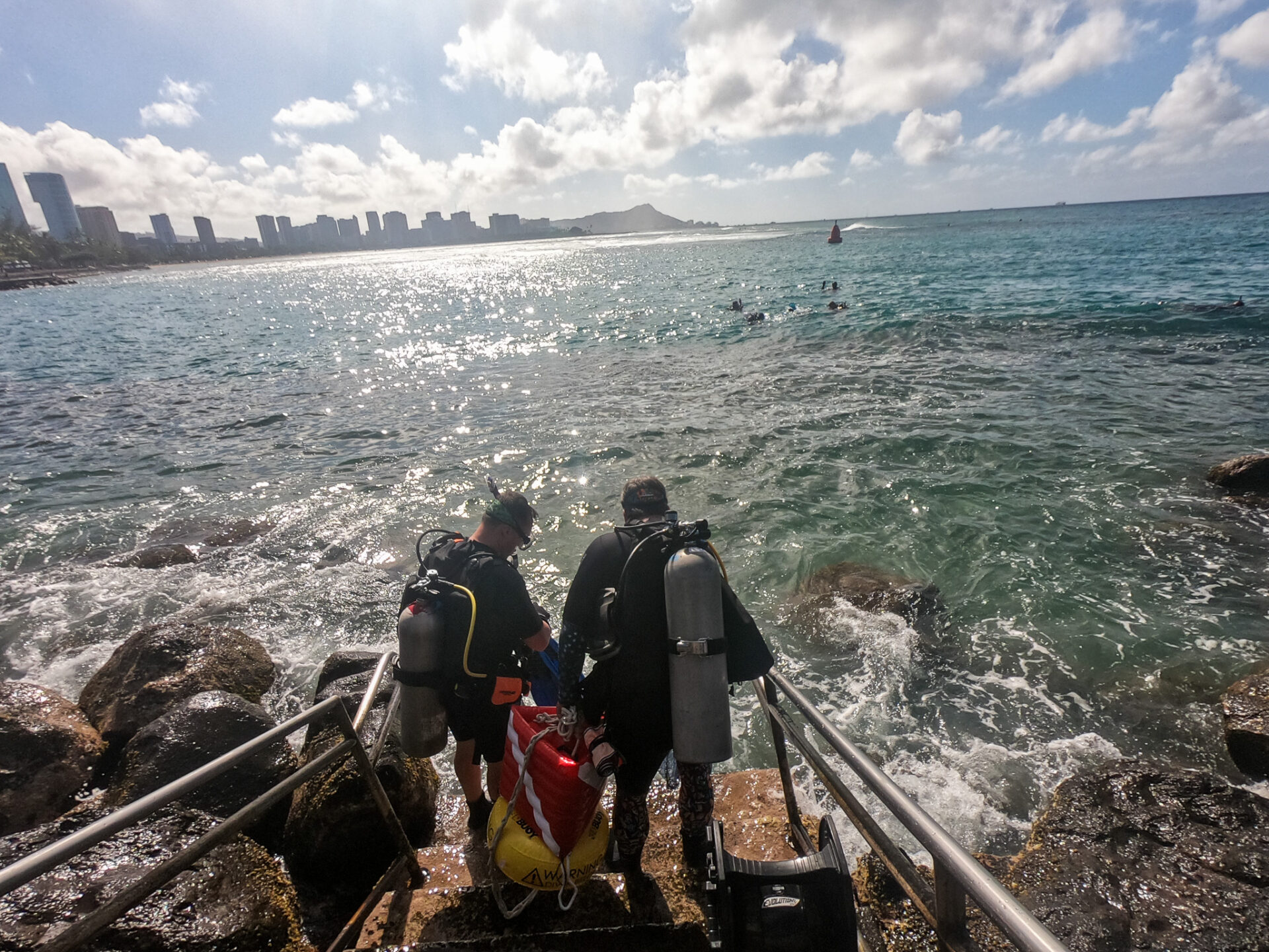 Nudi Wear volunteer divers entering the water at Point Panic for a cleanup dive