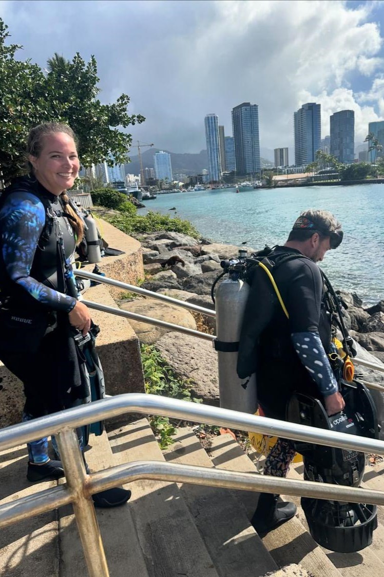 Nudi Wear owners, Christy and Ryan, entering the water at Point Panic, a popular dive site on Oahu