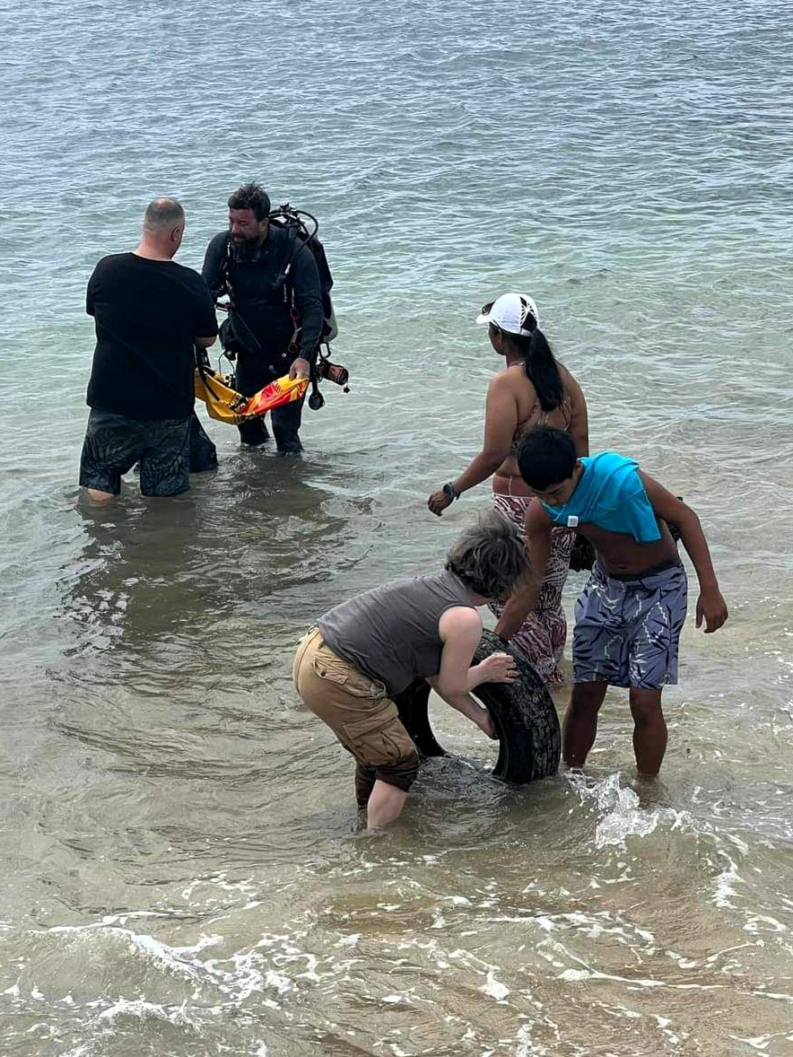 Land support helping divers to remove heavy items, such as the tire pictured from the ocean