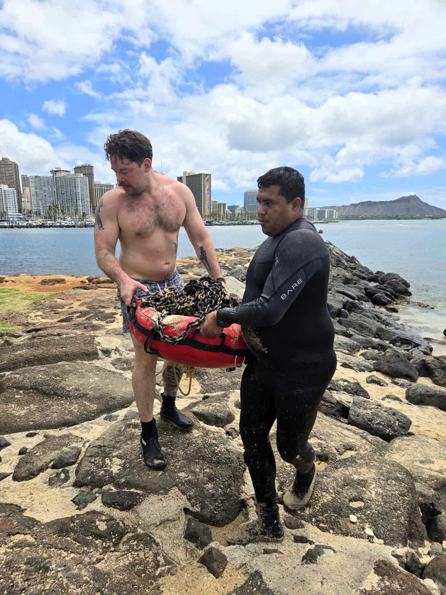 Divers removing a large abandoned chain from Magic Island's dive site