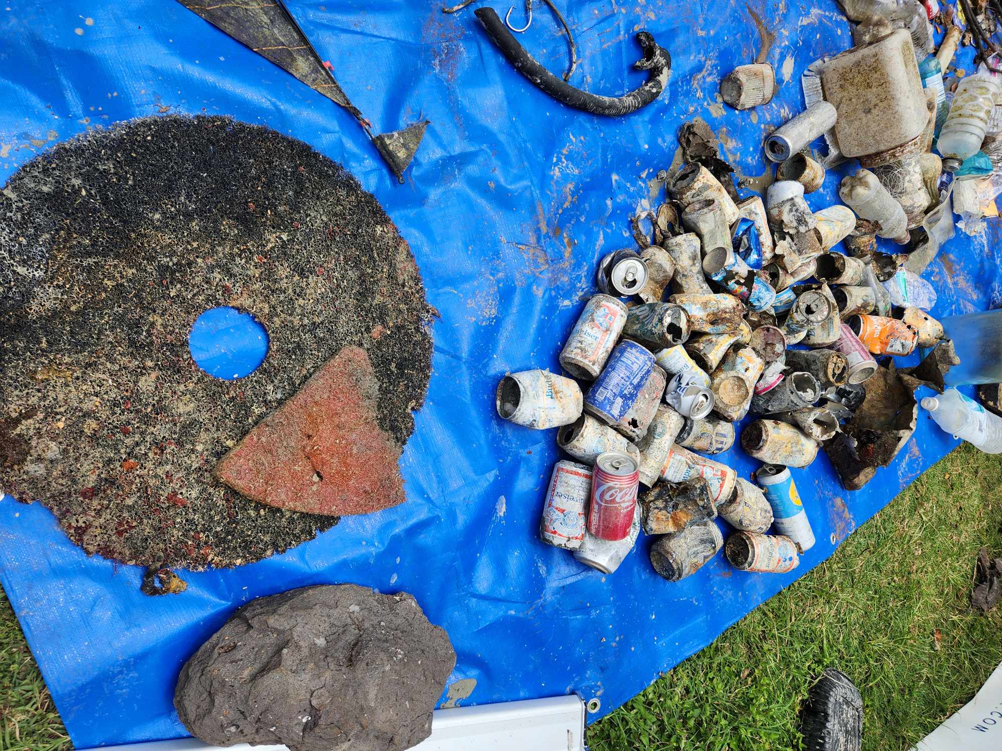 A buffing pad and aluminum cans removed from the ocean during a Dive Against Debris at Nudi Wear's Adopt The Blue dive site