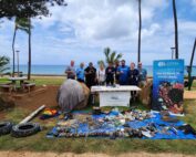 Nudi Wear volunteers posing with marine debris removed at a Dive Against Debris