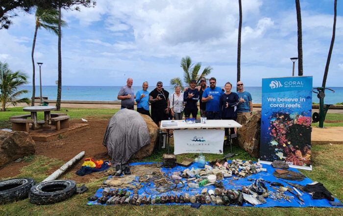 Nudi Wear volunteers posing with marine debris removed at a Dive Against Debris