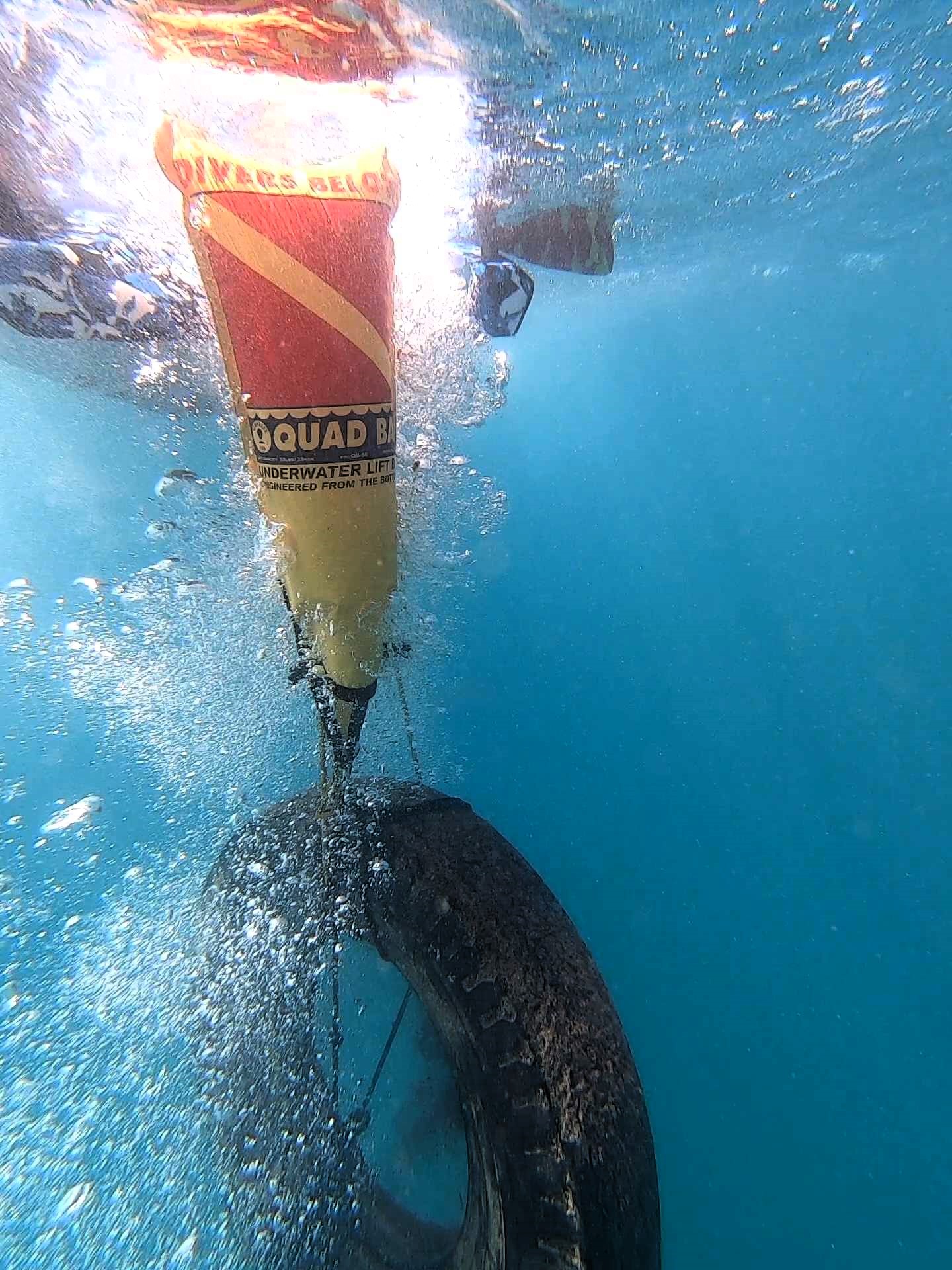 Nudi Wear volunteers using lift bags to remove tires from Makaha dive site