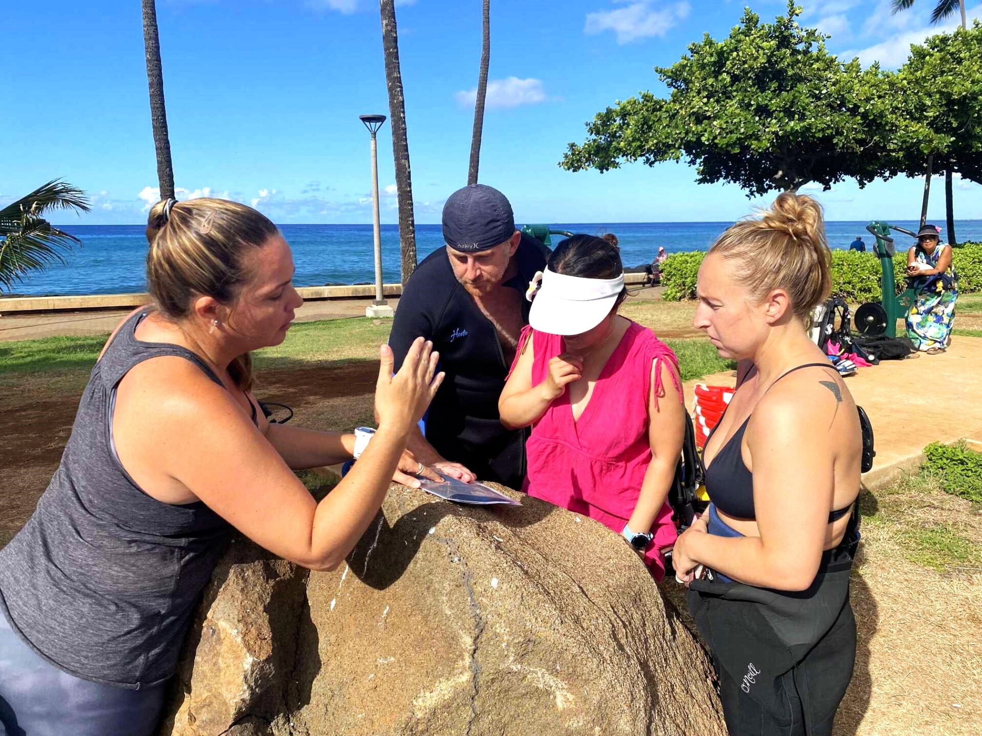 Nudi Wear owner, Christy Johnson, providing a dive site briefing to volunteers aimed at removing marine debris in Hawaii