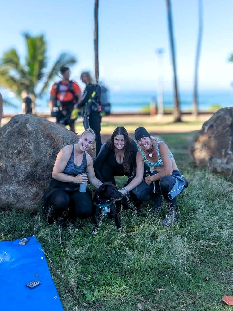 Nudi Wear volunteers taking a break with a dog