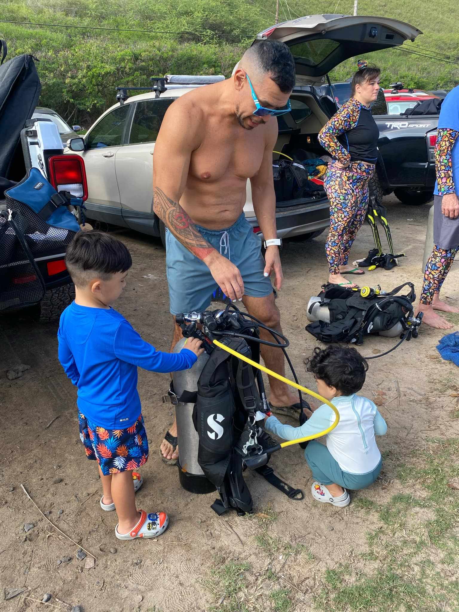 Kids helping dad set up scuba gear