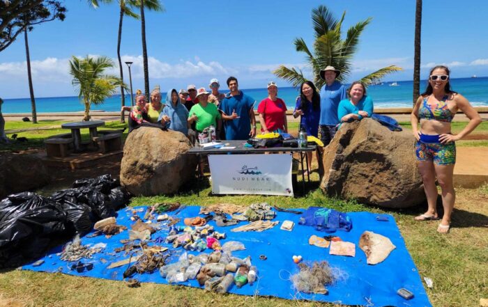 Nudi Wear volunteers posing with trash they pulled out of the ocean