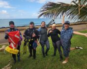 A group of female volunteer divers from the Nudi Wear, Aaron's Dive Shop, and Ocean Alliance Project excited for the cleanup dive